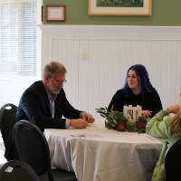 Dean of Brooks College Mark Schaub at a table having a conversation with fellow event attendees